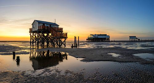 Stapelwoningen aan de Noordzeekust op het strand van St. Peter Ording bij zonsondergang