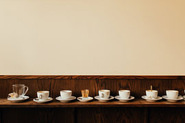 Nach Feierabend – Eine Reihe leerer Kaffeetassen von Mohit Hambiria