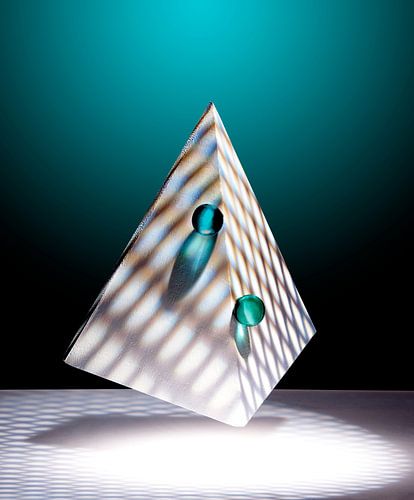 Zwevende piramide met twee groene knikkers.