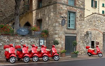 Rode Vespa scooters in een Italiaans straatje.