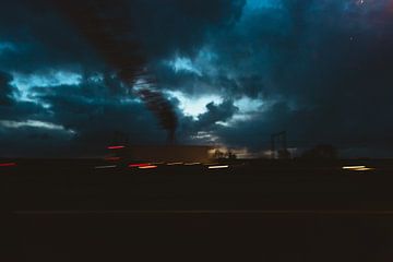 Lichten van een auto op een dondere avond op de snelweg van Koen Verburg