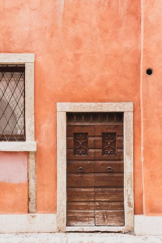 The front door of a coral-colored Italian house