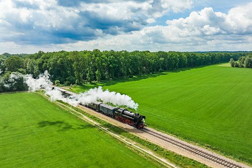 Stoomtrein met rook uit de locomotief in het landschap van boven
