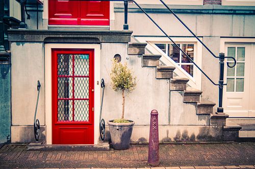 Amsterdams grachtenpand met rode deur en trap