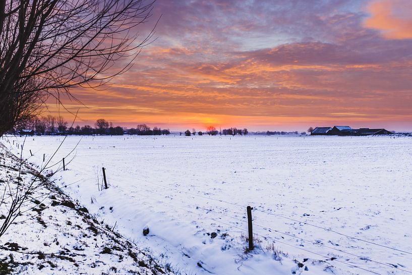 Avondrood in de winter boven sneeuwlandschap van Fotografiecor .nl