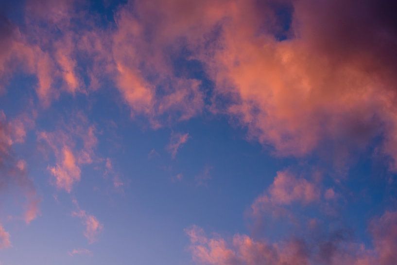 orange clouds against blue sky by SchraMedia