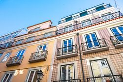 Gele tegels en buitenmuur van oude gebouwen in de oude wijk Alfama in Lissabon.
