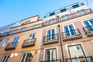 Gele tegels en buitenmuur van oude gebouwen in de oude wijk Alfama in Lissabon. van Christa Stroo fotografie