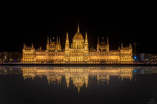 Het Hongaarse parlement in de nacht en de reflectie van het parlement in de Donau