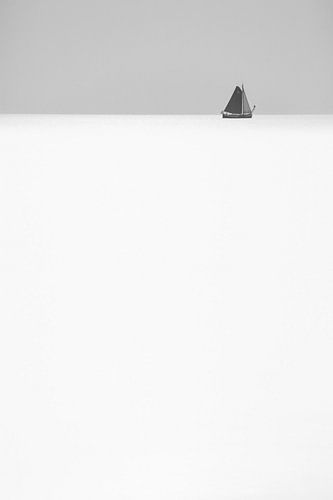 Zwart-wit abstracte foto van een zeilschip aan de horizon op zee