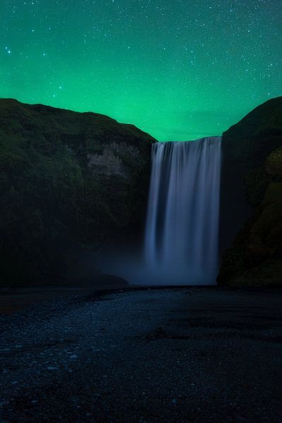 Northern lights above the waterfall Skogafoss in Iceland. by Jos Pannekoek