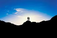 Silhouetten von zwei Personen, die bei Sonnenuntergang auf einem Berg stehen. Wout Kok One2expose von Wout Kok Miniaturansicht