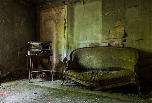 Oude bank en radio in een urbex huisje.