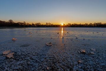 Stuk ijs op een bevroren meer tijdens een warme zonsopkomst van Kim Willems