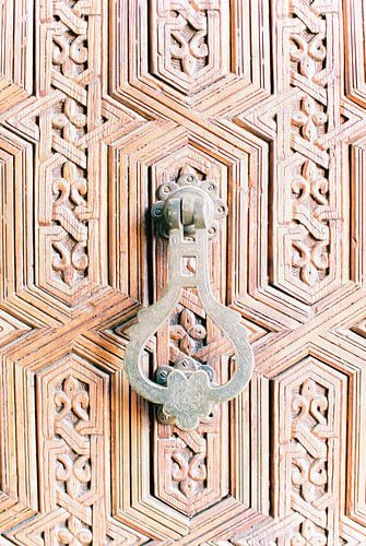Bronze door knocker on wooden door in Marrakesh, Morocco