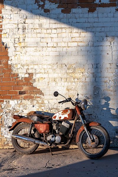 Roestige motor tegen bakstenen muur van Art & Soul Creations
