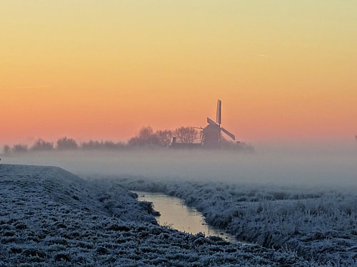 Molen met mist en rijp bij zonsopkomst