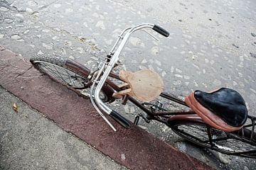 Geparkeerde oude fiets op de stoep van een vieze oude straat als achtergrond in Havana, Cuba van Tjeerd Kruse