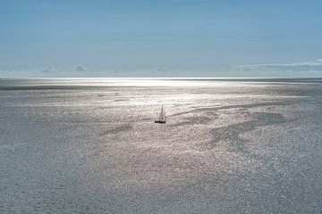 Zeilbootje op de oceaan in het tegenlicht van de zon .