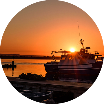 Oranje zonsopgang boven een boot met zonnestralen van Gea Gaetani d'Aragona