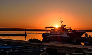 Oranje zonsopgang boven een boot met zonnestralen van Gea Gaetani d'Aragona