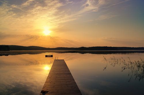 Loopbrug, naar de zonsopgang, reikend in een Zweeds meer