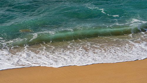 Golven op een zandstrand met helder water