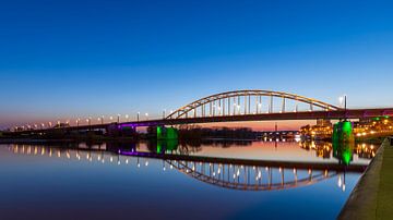 Die Arnheimer John-Frostbrücke am Abend über einem flachen Rhein
