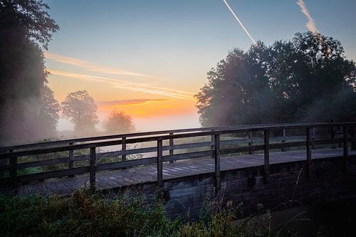 Pont en bois lors d'un lever de soleil brumeux