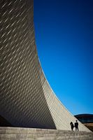 Twee mensen wandelen voor het MAAT-museum in Lissabon
