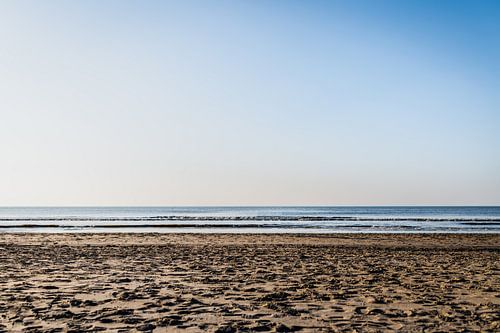 Zon, zee, strand met een heldere blauwe lucht