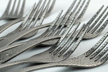 Abstract artistic photograph of cutlery, being eight lying forks with waterdrops against a white bac by Tonko Oosterink