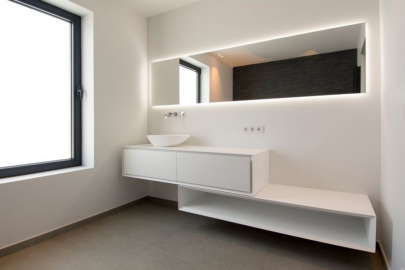 witte badkamer met spiegel en kast en natuurlijk licht von Ribbi