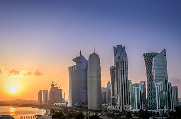 De skyline van Doha in Qatar tijdens zonsondergang