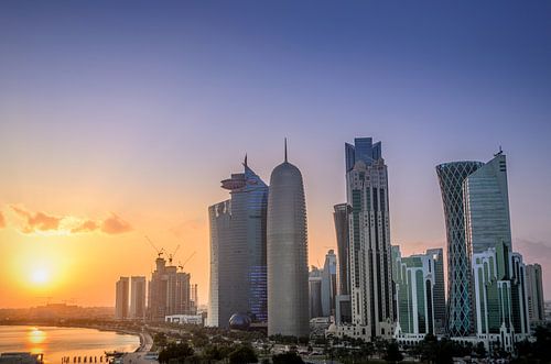 De skyline van Doha in Qatar tijdens zonsondergang