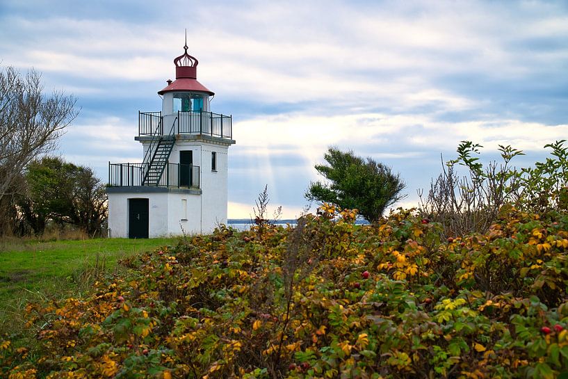 Lighthouse by the sea and rays of sunshine by Martin Köbsch