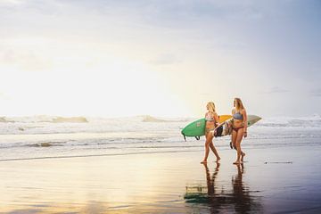 Surfers tijdens zonsondergang. van Andy Troy