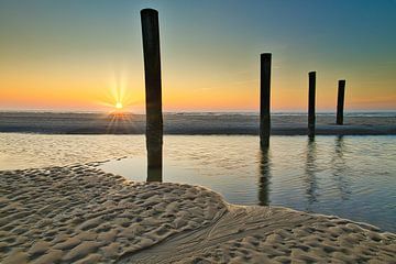 4 piles at sunset near Petten by peterheinspictures