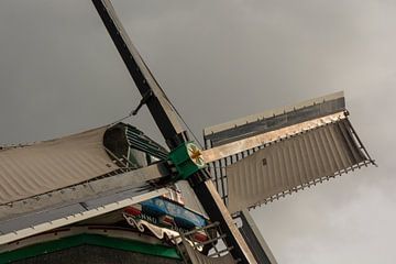 Die Segel der Zaanse-Windmühlen und ein bedrohlicher Himmel. von Zaankanteropavontuur