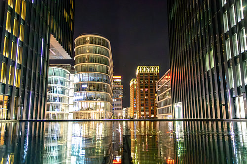 A striking reflection of illuminated modern architecture in Düsseldorf’s Medienhafen at night