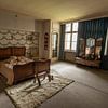 In een oud verlaten herenhuis een gedateerde slaapkamer. van Het Onbekende