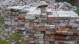stacked bricks and old construction helmet on a building site
