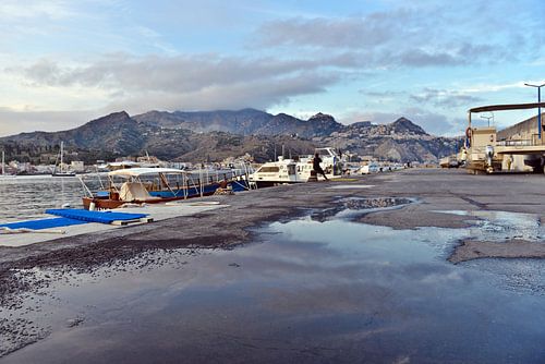 De avondlucht wordt weerspiegeld in de haven van Giardini Naxos