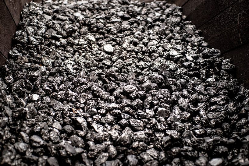 Piled black shiny coal in a wooden box for old industry by Fotografiecor .nl