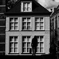Silhouet van man met boodschappentas op de Oude Delft