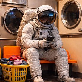 Pause lessive cosmique – Un astronaute attend dans une laverie automatique rétro sur Dodik Hariyono
