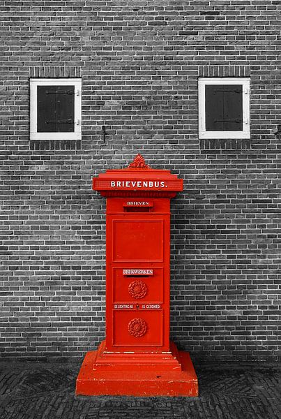 Rode brievenbus tegen muur in zwart wit van Yvonne Smits