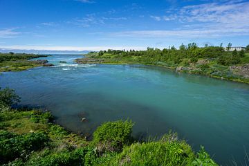 Islande - Eau turquoise d'une rivière entre des plantes vertes se jetant dans l'océan sur adventure-photos