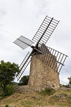 Old, historic windmill in Grimaud with the Massif des Maures in France in spring, Côte d'Azur