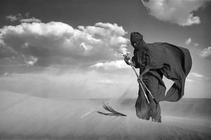Sahara-Wüste. Ein Mann vom Stamm der Tuareg fährt mit Skiern eine Sanddüne hinunter.